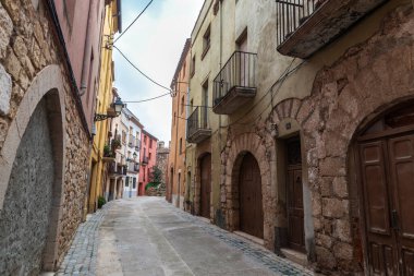 Montblanc, Tarragona, Katalonya, İspanya 'nın taşra köyünün duvarlarının yanındaki tipik evlere sahip sokak.