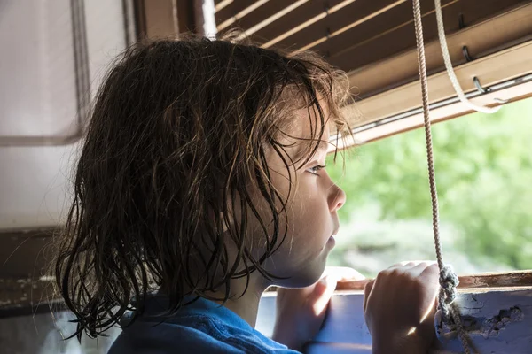 Kız pencereden dışarı bakıyor.