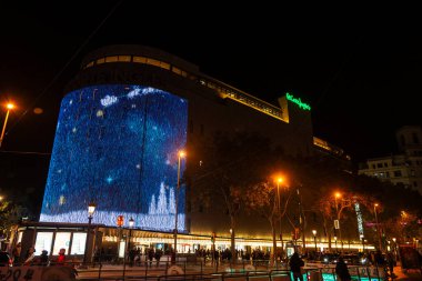 Barselona, İspanya - 25 Kasım 2025: El Corte Ingles mağazasının ön cephesi ve sokakta asılı duran Noel ışıkları geceleri Katalonya Meydanı, Barselona, Katalonya, İspanya