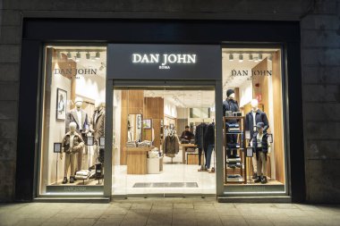 Barselona, İspanya - 25 Kasım 2025: Portal de Angel 'daki Dan John lüks giyim mağazası, geceleri Barcelona, Katalonya, İspanya' da insanların dolaştığı bir alışveriş caddesi