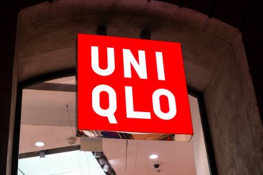 Barselona, İspanya - 25 Kasım 2025: Barcelona, Katalonya, İspanya 'da bir alışveriş caddesinde geceleyin Uniqlo giyim mağazasının imzası