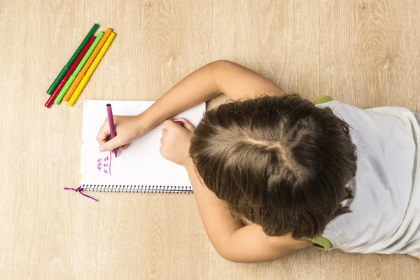 En liten flicka som gör läxor — Stockfoto
