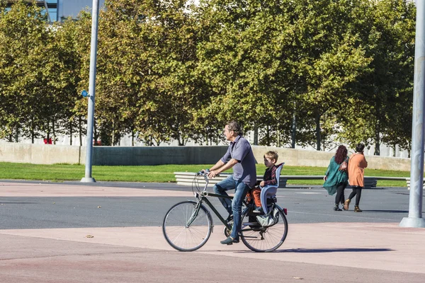 Padre cargando a su hijo pequeño en bicicleta en Barcelona — Foto de Stock