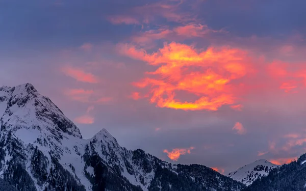 На красивом зимнем закате облака окрашены ярко-красным и оранжевым цветом — стоковое фото