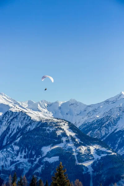 Tandum yamaç paraşütçüleri aşağıdaki sert karla kaplı dağların üzerinde süzülür.