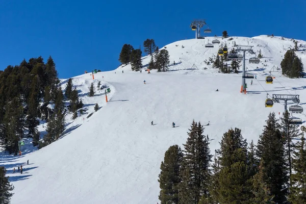 雪に覆われた山を楽しむスキーヤーやスノーボーダー ストック画像