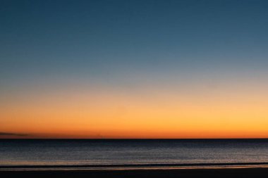 Gün batımında son güneş ışınları ve onun yansıması renkli gökyüzünde ve denizde
