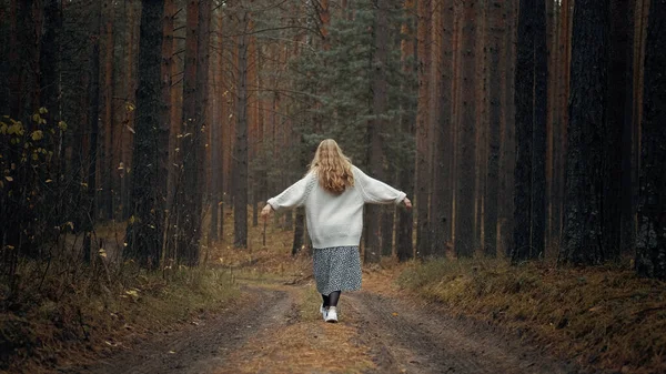 Una chica con un vestido y un suéter blanco camina por el bosque —  Fotos de Stock