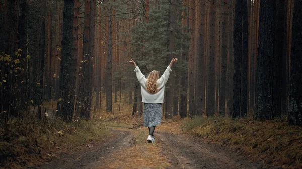 Una chica con un vestido y un suéter blanco camina por el bosque —  Fotos de Stock