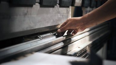 Teknisyen hidrolik bükme makinesi kullanıyor. Metal çalışma konsepti