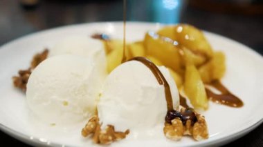 Lezzetli narsharab soslu kızarmış portakal ve elmalı vanilyalı dondurma. Ceviz. Kapat.