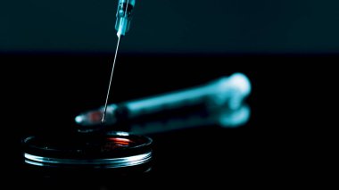 Kan damlalı şırınga iğnesi. Arkaplanda şırınga