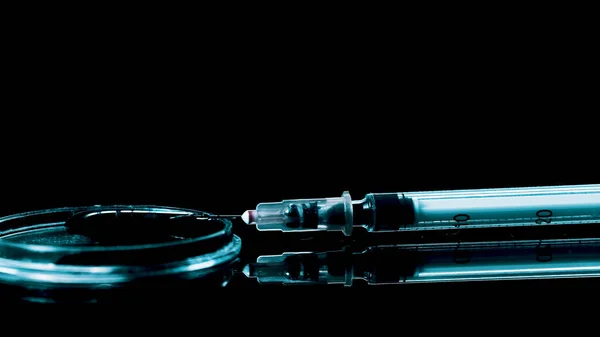 Uma seringa com drogas jaz na mesa e o sangue goteja — Fotografia de Stock
