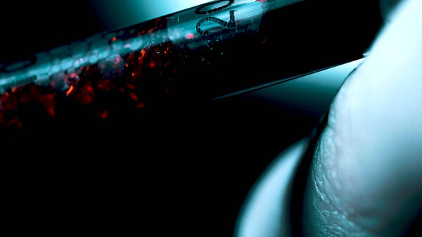 Hand holding a syringe and taking a blood sample for analysis