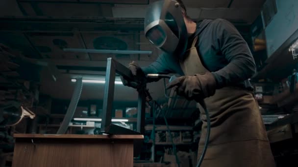 Metal parçaları lehimleyen maske ve eldiven giyen bir işçi. — Stok video