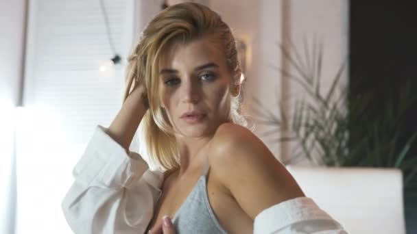 TOMSK, RUSSLAND - 16. August 2020: Sexy blondes Mädchen in Calvin Klein Unterwäsche und Hemd auf dem Bett. Porträtshooting — Stockvideo