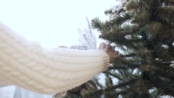 Vrouwelijke handen versieren kerstboom met speelgoed thuis — Stockvideo