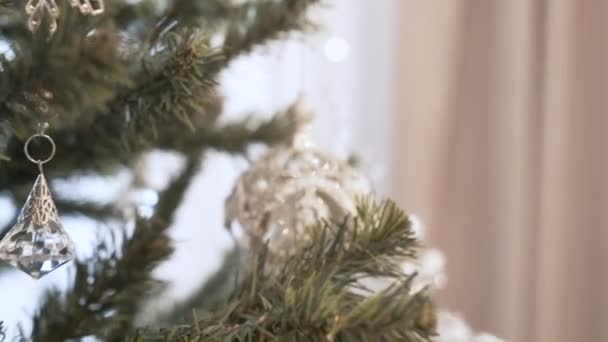 Vrouwelijke handen versieren kerstboom met speelgoed thuis — Stockvideo