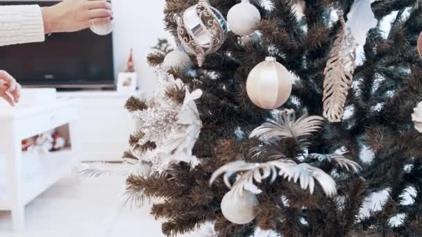 女性的手在家里用玩具装饰圣诞树。漂亮的圣诞玩具 — 图库视频影像