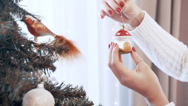 Vrouwelijke handen versieren kerstboom met speelgoed thuis. Prachtige paddenstoel — Stockvideo