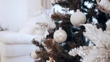 Güzel açık renkli oyuncaklar evdeki Noel ağacında asılı duruyor..
