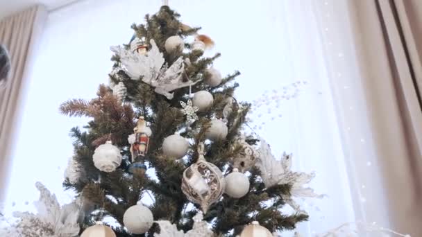 身穿白衣的漂亮的黑发女孩在圣诞树上装上玩具 — 图库视频影像