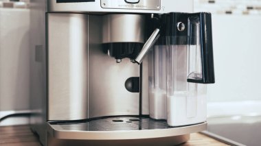 Kadın eli kahve makinesine bir bardak koyar.