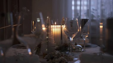 Kız yılbaşı şenlik masasında bir mum yakıyor. Tablo ayarı
