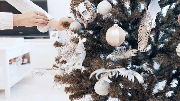 Weibliche Hände schmücken den Weihnachtsbaum zu Hause mit Spielzeug. Wunderschönes Weihnachtsspielzeug — Stockfoto