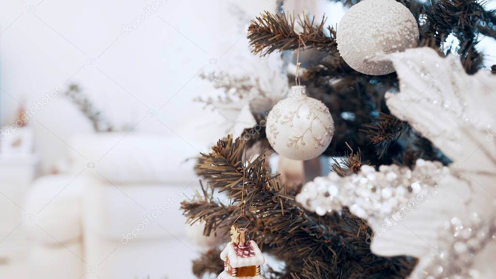 Female hands decorate christmas tree with toys at home. Beautiful christmas toys