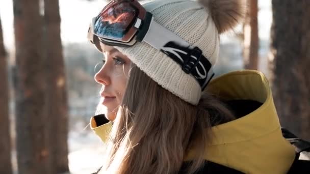 Дівчина в білому капелюсі і рюкзак в лісі взимку — стокове відео