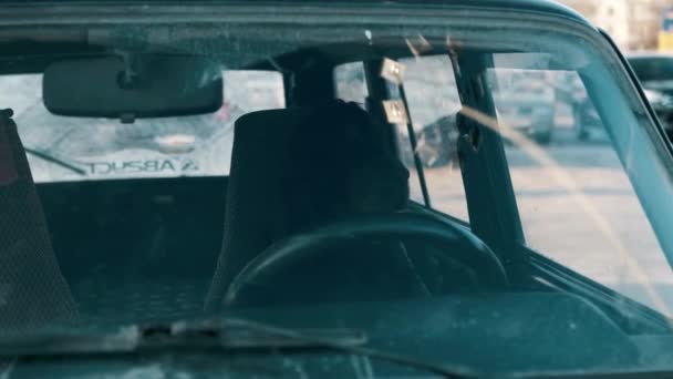 Czarny pies siedzi za kółkiem starego samochodu i czeka na właściciela — Wideo stockowe
