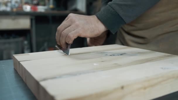 A carpenter applies a putty to a loft-style chair made of wood. — Stock Video