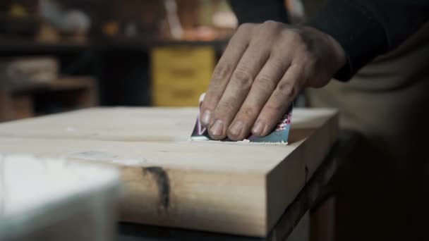 Seorang tukang kayu mengaplikasikan sebuah getah pada sebuah kursi bergaya loteng yang terbuat dari kayu. — Stok Video