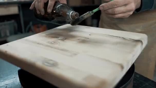 En snickare målar en träbit till en loftstol med pensel. Närbild — Stockvideo