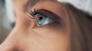 Kışın ormanda beyaz şapkalı ve kar maskeli bir kız. Yan görüş. Makro gözler. Bulanık arkaplan