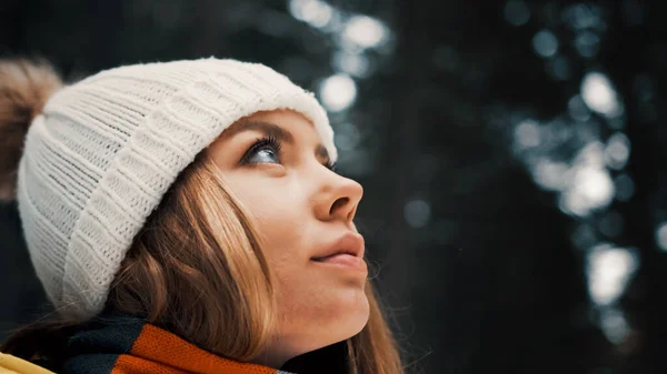 Ragazza con un cappello bianco nella foresta con uno zaino in inverno. Vista laterale. Da vicino. — Foto Stock