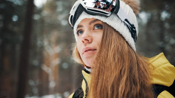Fehér kalapos lány hódeszkás maszkkal az erdőben télen. Oldalnézetből. Közelről. — Stock Fotó