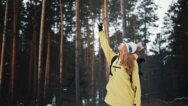 Девушка пытается поймать связь в лесу зимой — стоковое фото