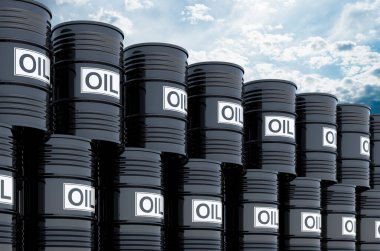 Mavi gökyüzüne karşı siyah yağ varilleri yığılıyor.