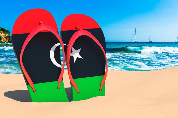Flip flops with Libyan flag on the beach. Libya resorts, vacation, tours, travel packages concept. 3D rendering