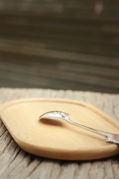 Spoon on a background of brown wood. — Stock Photo, Image