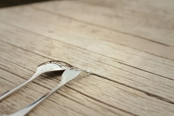 Spoon and fork on a background of brown wood. — Stock Photo, Image