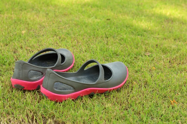 Czarne buty leżące na zielonej trawie. — Zdjęcie stockowe