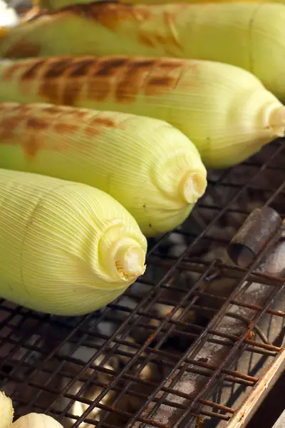 Corn is grilled on the furnace at the market — Stock Photo, Image