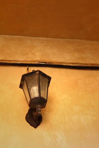 Une lampe sur un mur sur fond brun . — Photo