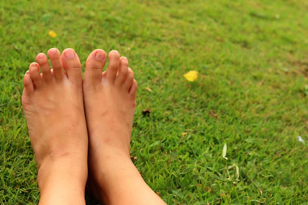 Foot on the green grass in the lawn. — Stock Photo, Image