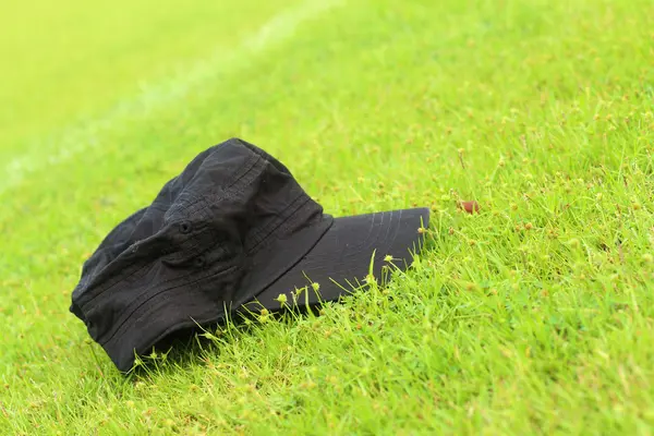 帽躺在绿色的草地. — 图库照片