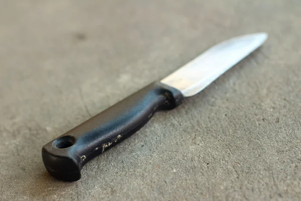 Gri bir arka plan üzerinde bir mutfak bıçağı.