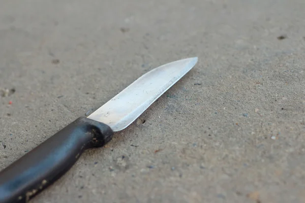 Gri bir arka plan üzerinde bir mutfak bıçağı.